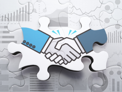 Two hands shaking on a puzzle piece, symbolizing partnership and collaboration.
